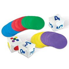 a set of numbers and dices on a white surface with colored discs around them