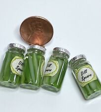 four jars filled with green liquid next to a penny