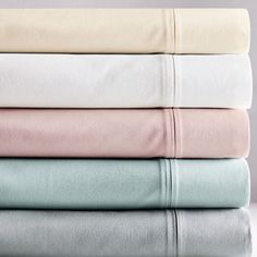 four sheets stacked on top of each other in different colors and sizes, with one folded