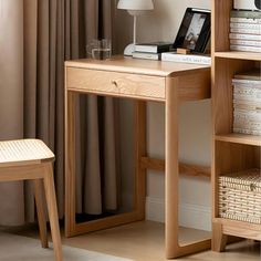 a wooden desk sitting next to a book shelf filled with books and a lamp on top of it