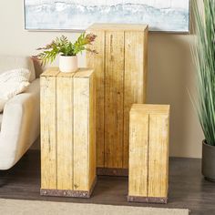 three wooden planters sitting next to each other in front of a couch