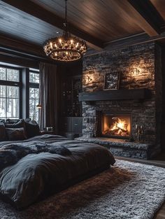 a large bed sitting in front of a fire place under a chandelier on top of a wooden floor