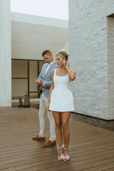 a man standing next to a woman talking on a cell phone