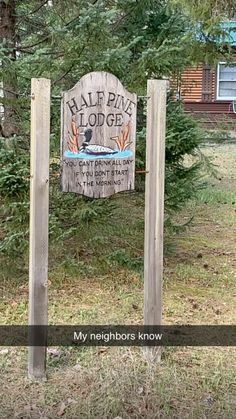 a sign that is in the grass by some trees and bushes with words on it