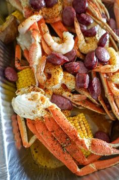 lobster and corn on the cob are served in a serving dish with red wine