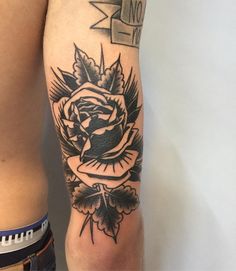 a man's arm with a rose tattoo on the left side of his body