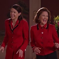 two women dressed in red are laughing and standing next to each other with their hands out