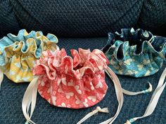 three small purses sitting on top of a blue couch next to each other and tied together