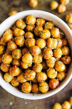 a white bowl filled with roasted chickpeas on top of a table next to other food