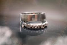 two wedding rings sitting on top of a table with frosted glass in the background