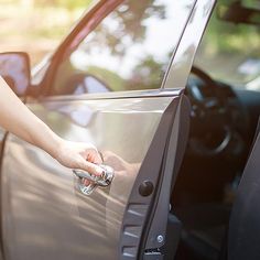 a woman is opening the door of her car