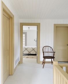 a chair sitting in the middle of a room next to a door and a bed