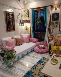 a living room filled with lots of furniture and plants on top of the couches