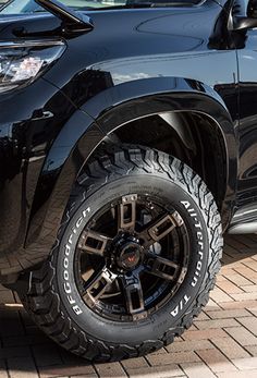 a black truck parked on top of a brick road