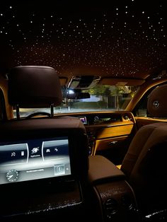 the interior of a car with stars on the ceiling and dash lights in the back