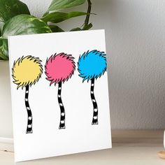 three colorful palm trees with black and white stripes on them art board print by artist unknown