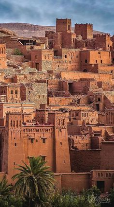 an old village in the desert with adobe buildings and palm trees on the hillsides