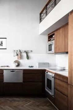 a kitchen with wooden cabinets and white walls, an oven, dishwasher and microwave