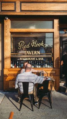 a man sitting at a table in front of a restaurant