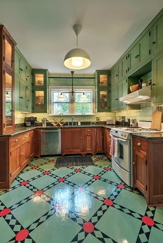 a kitchen with green cabinets and black and white checkered flooring on the tile