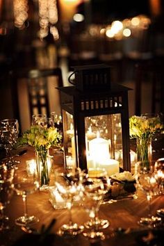 a lit candle sits on top of a table with flowers and candles in vases