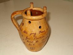 a ceramic jug with writing on it sitting on a white counter top next to a pen