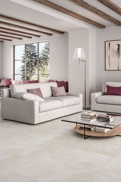 a living room filled with furniture and a large window covered in wood beams on the ceiling