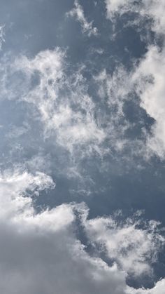 an airplane is flying through the cloudy sky