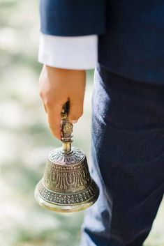 a close up of a person holding a bell