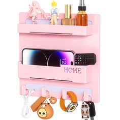 a pink phone holder with various items hanging from it's sides and the word home on top