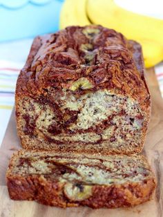 a loaf of banana bread sitting on top of a wooden cutting board