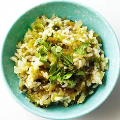 a blue bowl filled with rice and vegetables