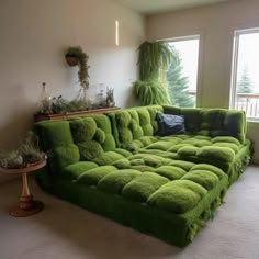 a green couch covered in grass next to a window