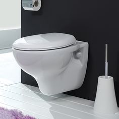 a white toilet sitting next to a black wall