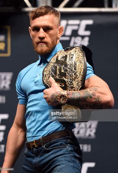 a man in blue shirt holding a wrestling glove