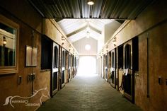 the inside of a horse stable with stalls lined up