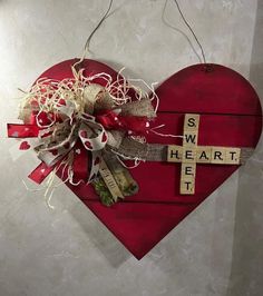 a red heart with a cross on it and some tags attached to the side that says, sweet heart let