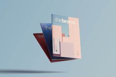 two magazines are flying through the air on top of each other, one is pink and blue