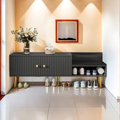 an entryway with shoes on the floor and a vase filled with flowers