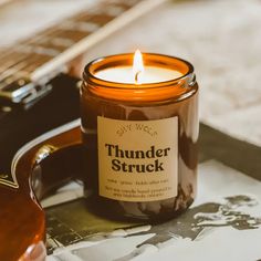 a candle that is sitting next to a guitar