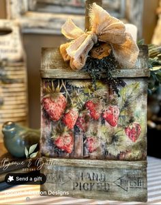 a wooden box with strawberries on it sitting on a table next to other items