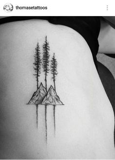 a woman's lower back with trees and mountains on her left side ribcage