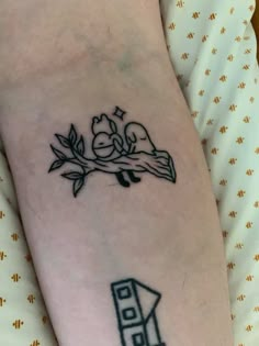 a tattoo on the arm of a person with a bird sitting on top of a tree branch