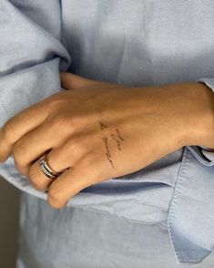 a woman's hand with a small tattoo on it