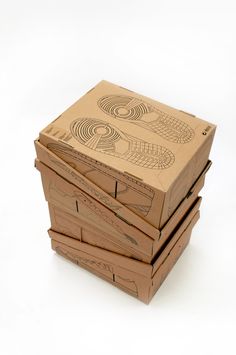 four cardboard boxes stacked on top of each other with designs on the lids and sides