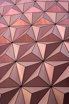 a close up view of a red and pink wall with geometric shapes on it's surface