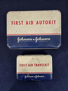 two first aid kits sitting on top of a blue cloth covered table next to each other