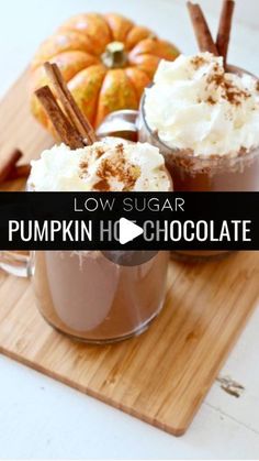 low sugar pumpkin hot chocolate with cinnamon and whipped cream in mugs on cutting board