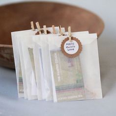 small clothes pins are placed on top of each other in front of a wooden bowl