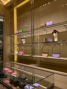 a display case filled with lots of purses and handbags on top of glass shelves